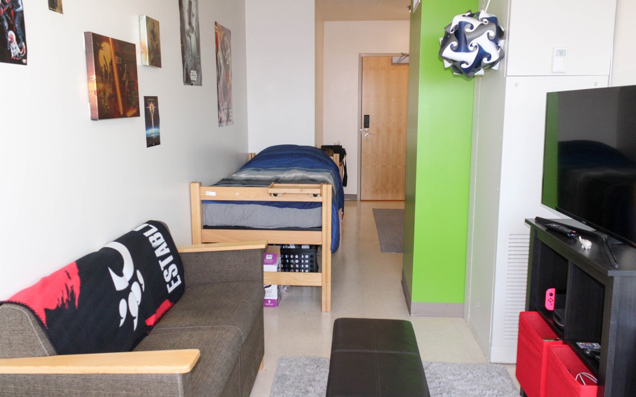 Living room and bed in single room in Scioto Hall.