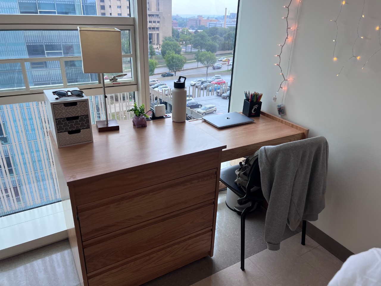 Desk facing the window in a Scioto bedroom with a laptop, lamp and other stationary on the desk