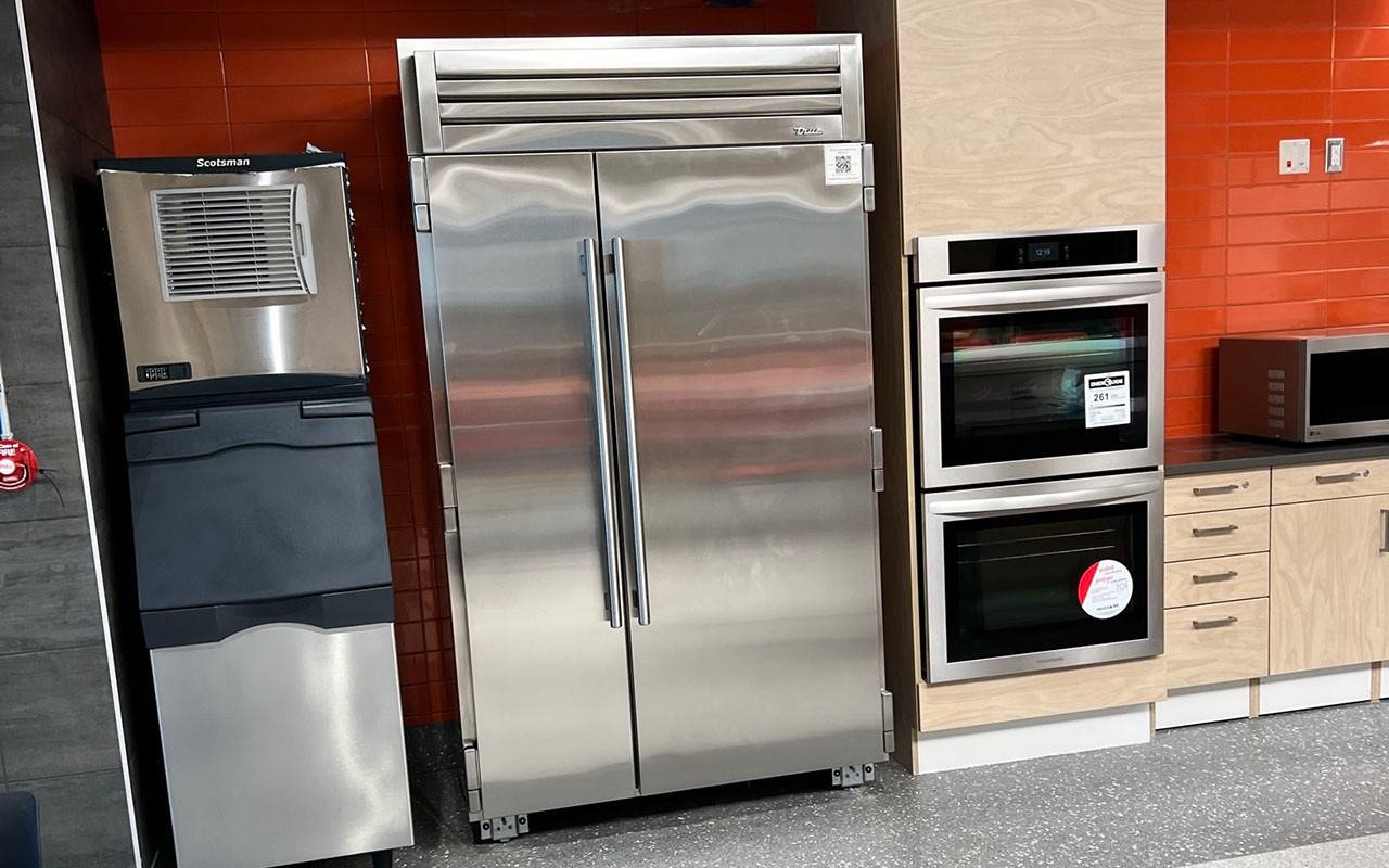Kitchen area with large refrigerator, ice machine, ovens and microwave