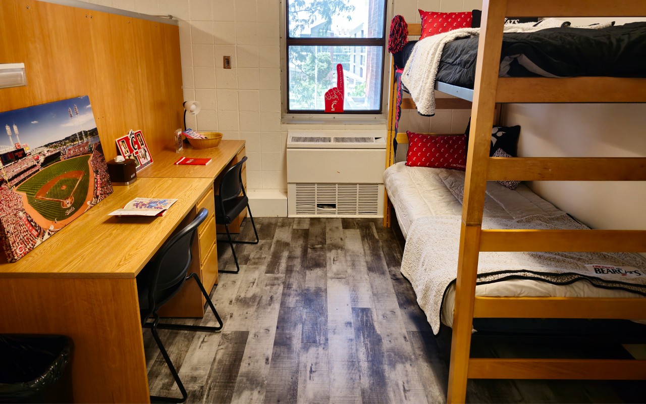 Bunk bed at right with 2 desks across aisle